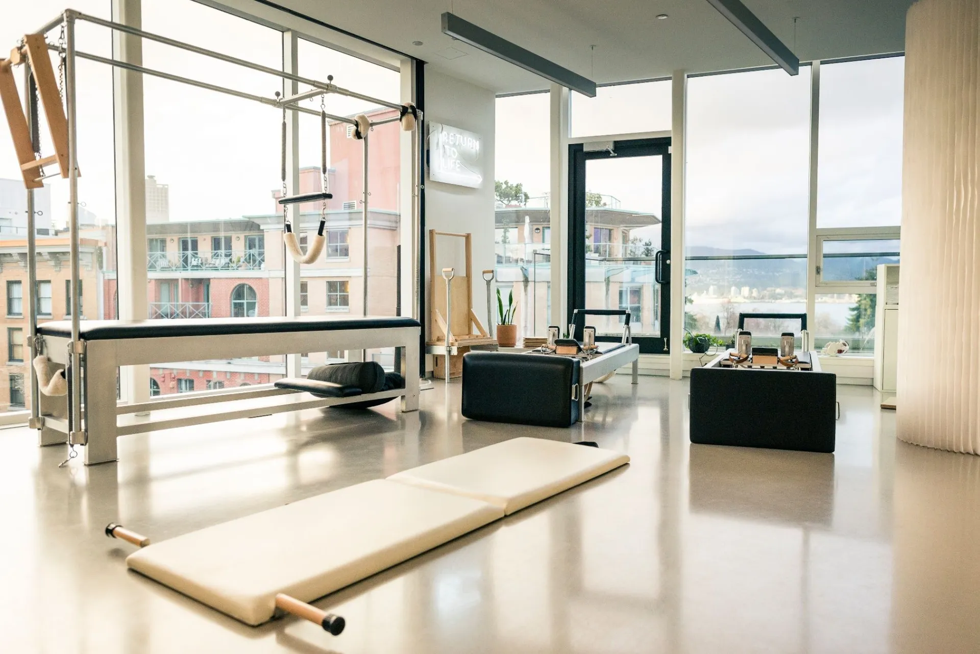 Reformers and Pilates apparatus in the rhōmē studio, with west coast views